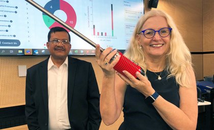 Aurtra CEO Terry Woodcroft (right) and UQ's Professor Tapan Saha (left). A woman holding a metal rod, with a man in suit looking on.